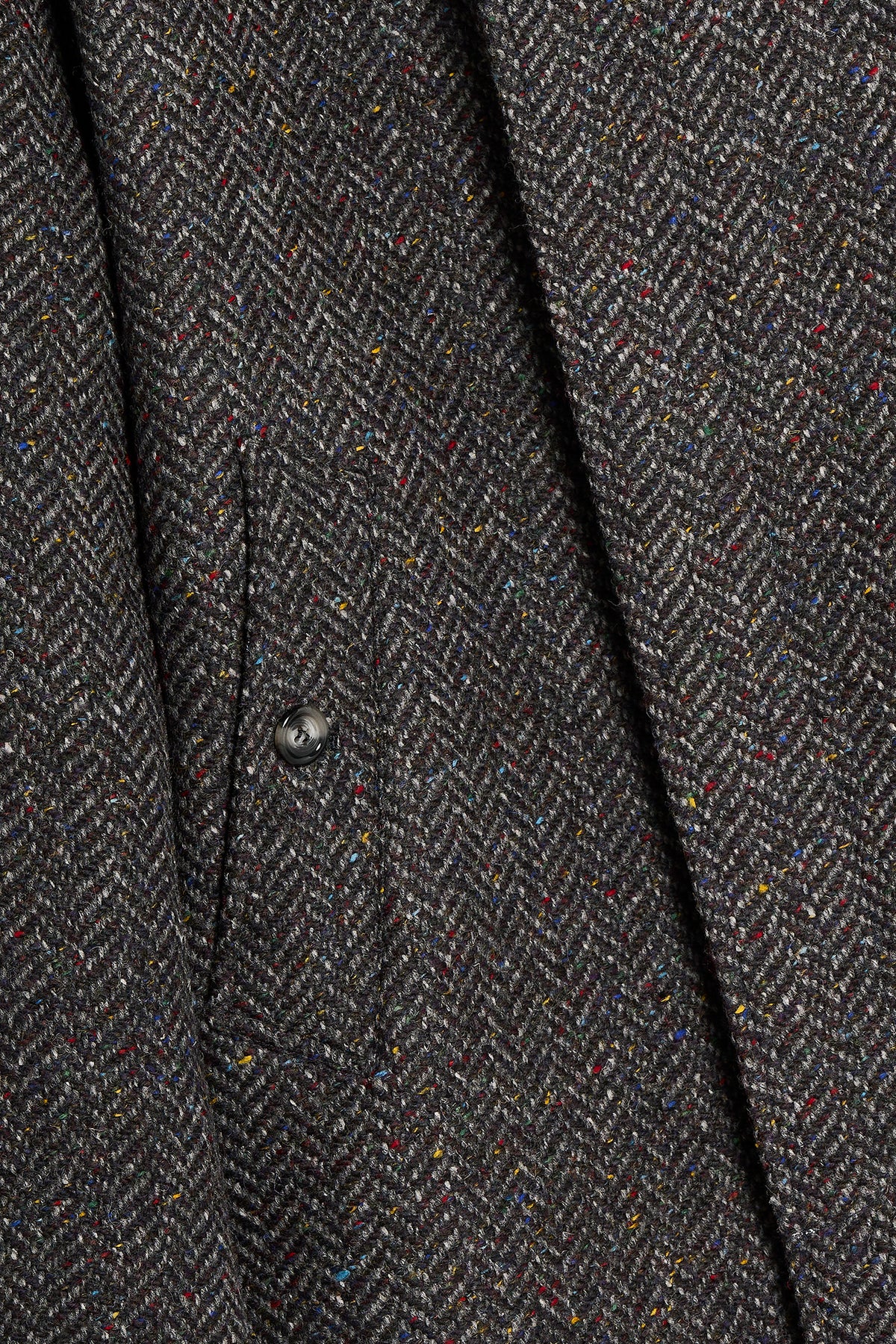 Dettaglio Donegal Herringbone Tweed grigio con trama a spina di pesce e flecks colorati